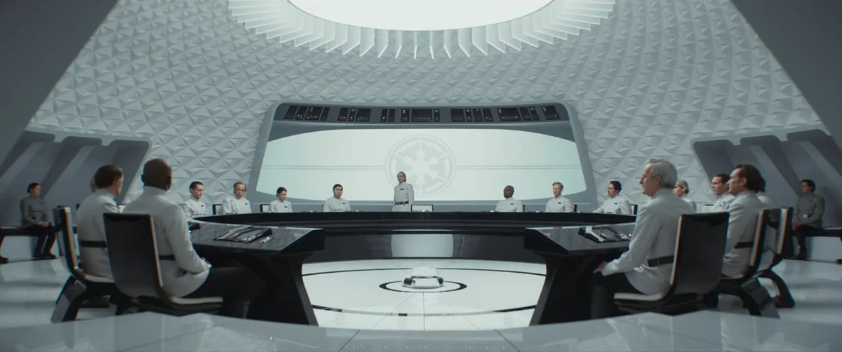 A still image from the show Andor, depicting a meeting among officers of the Empire